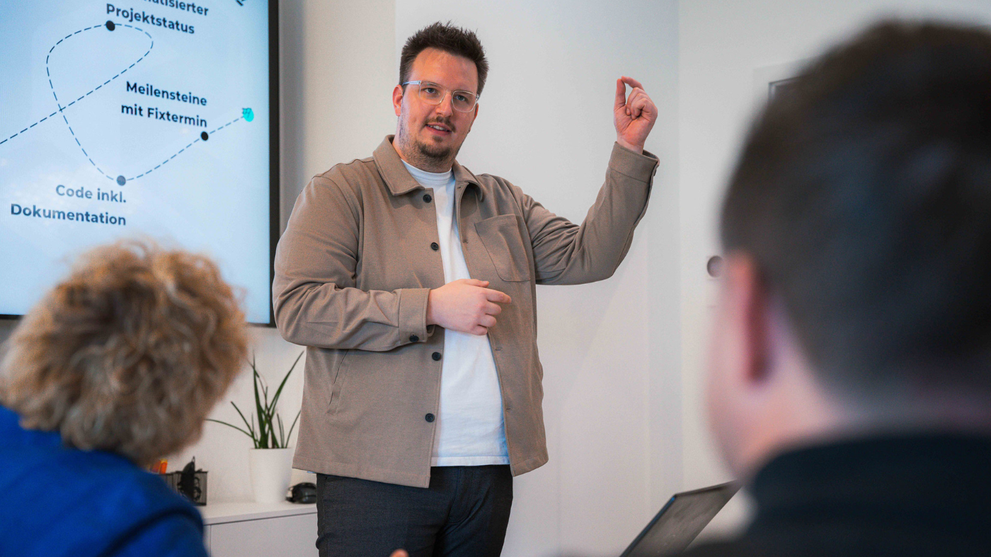 Erfolgreiche Facebook-Canvas-Anzeigen erstellen Ein Mitarbeiter gestikuliert während er präsentiert