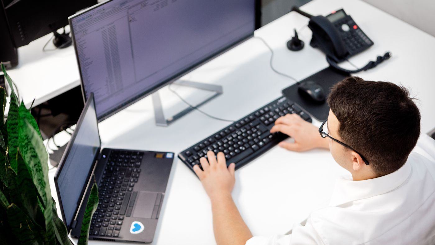 Web Design Trends 2020 Mitarbeiter sitzt vor zwei Monitoren, ansicht von oben