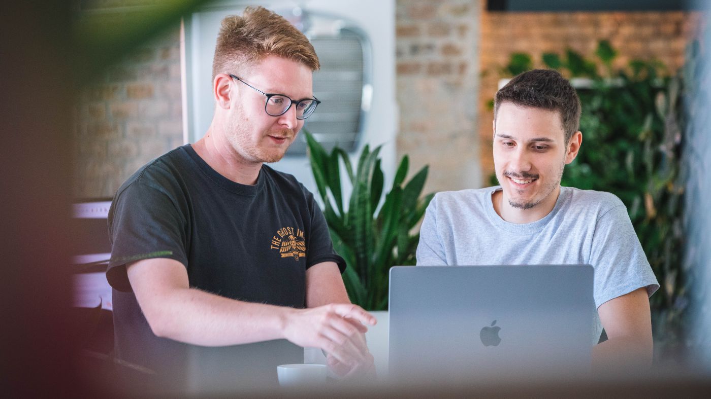 Instagram Engagement erhöhen Gespräch zwischen zwei Experten vor einem Notebook