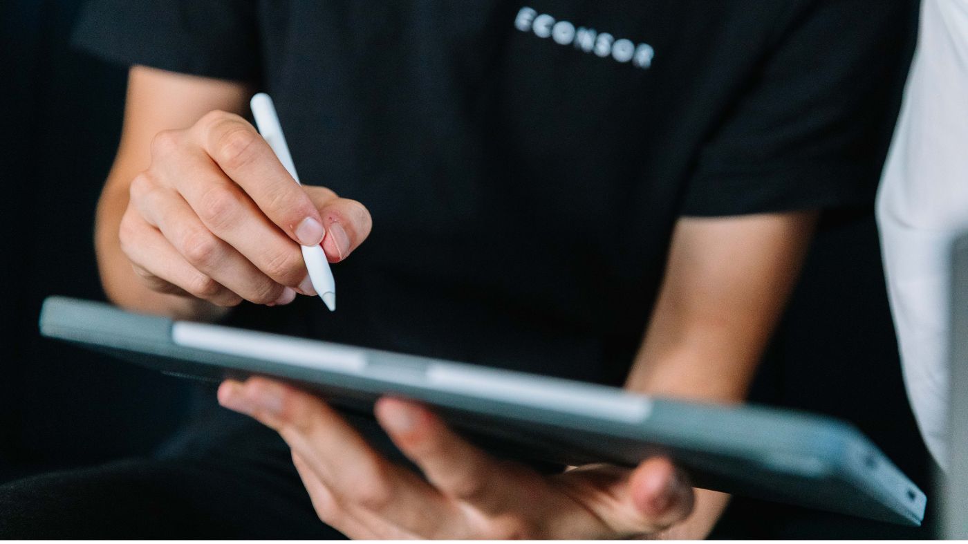 Instagram Story Anzeigen Eine Person hält ein Tablet in der Hand und schreibt darauf.